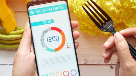 Un téléphone dans les mains d'une personne et montrant une application nutrition