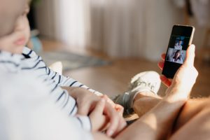 Un homme avec son bébé dans les bras en pleine téléconsultation médicale avec un médecin - bonjourdocteur