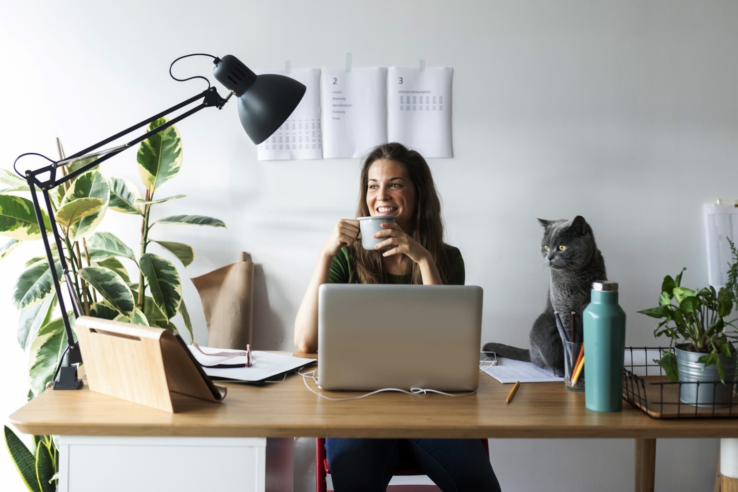 Une femme souriante devant son ordinateur - versements volontaires