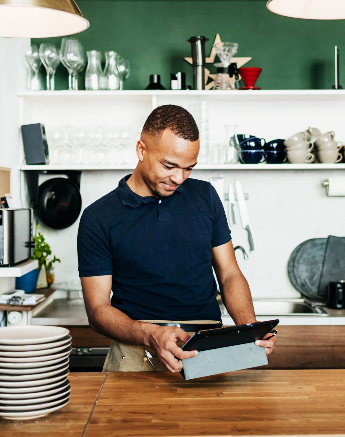 Un homme regardant sa tablette dans son café-restaurant - loi industrie verte