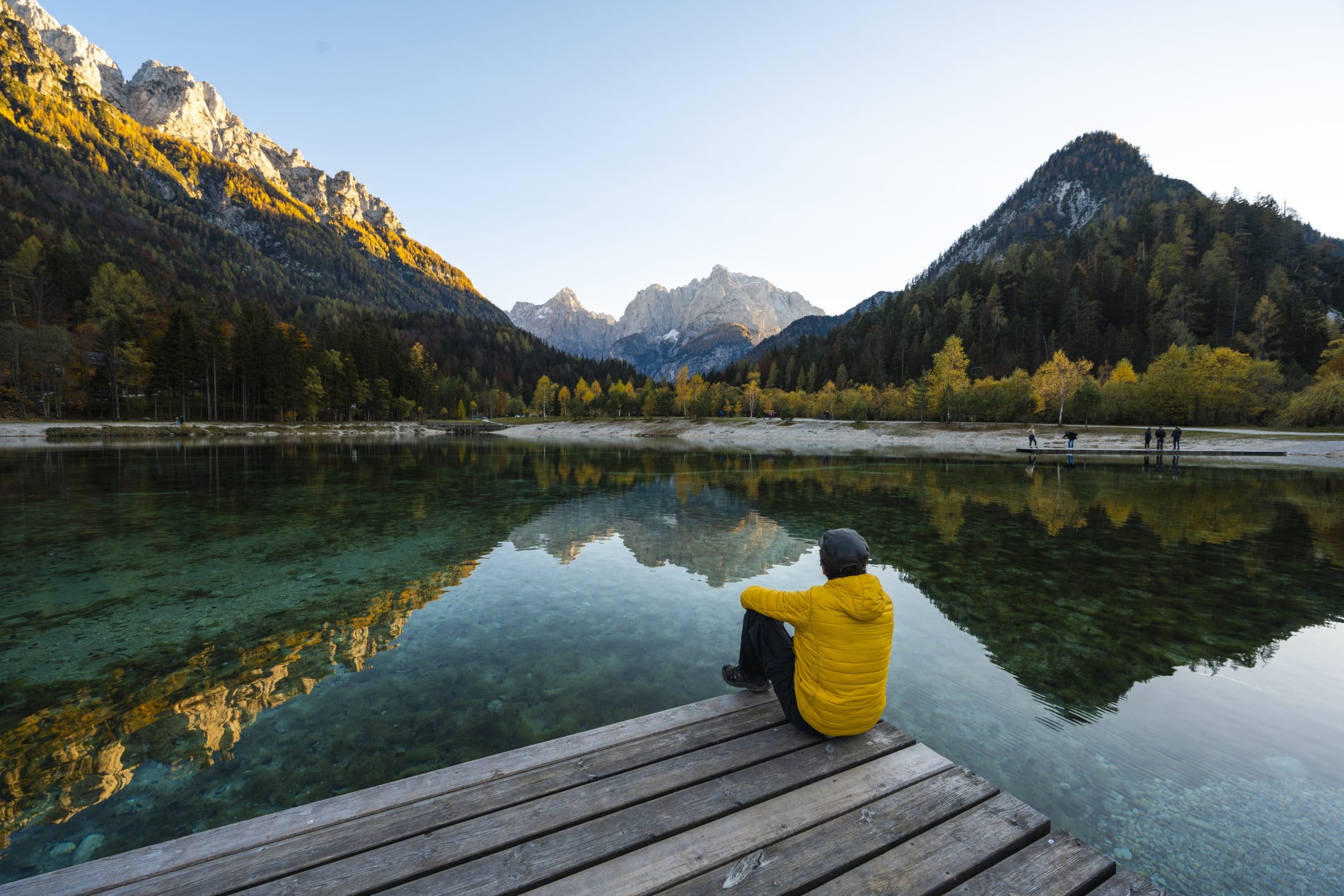 Un homme de dos regardant le lac et les montagnes face à lui - loi industrie verte