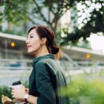 Une femme dehors avec un café à la main - PEE