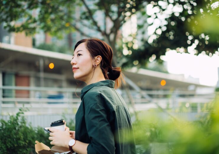 Une femme dehors avec un café à la main - PEE