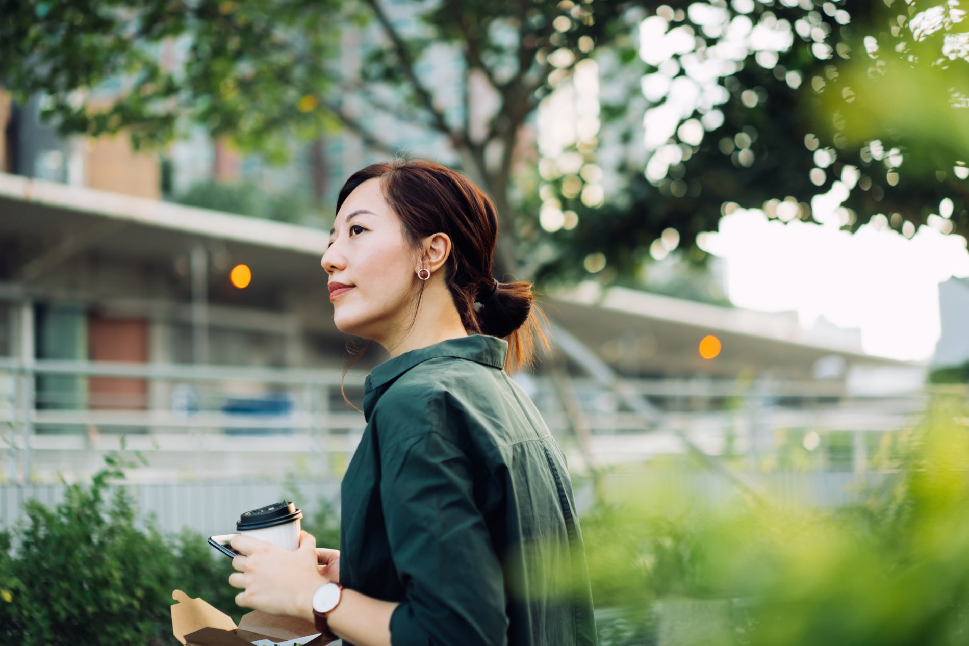 Une femme dehors avec un café à la main - PEE