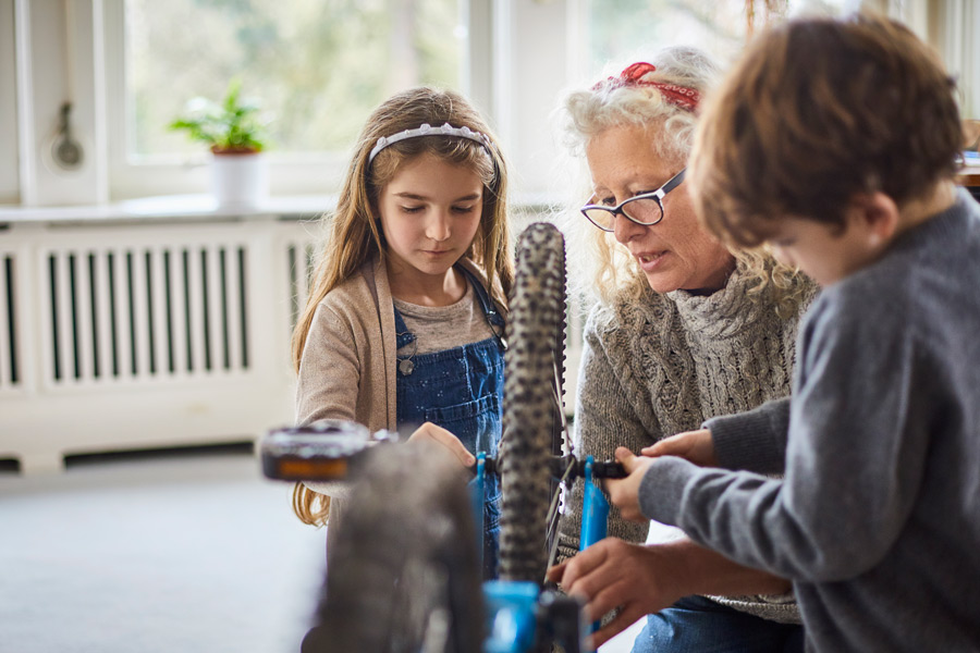 Une femme réparant un vélo avec ses petits enfants - Nouveautés 2025 Épargne salariale retraite